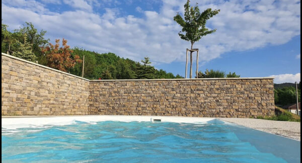steinriemchen lodge grey mit ecksteinen an einer sichtschutzwand fuer einen pool
